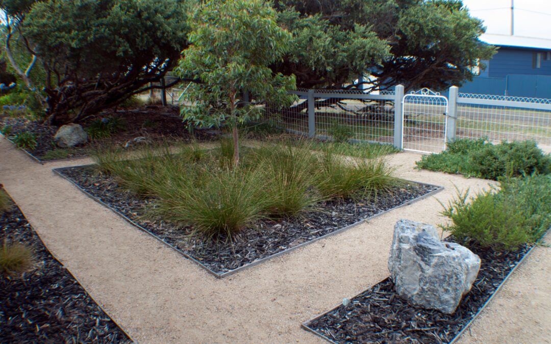 garden landscape with an area with woodchips and pebbled walkway
